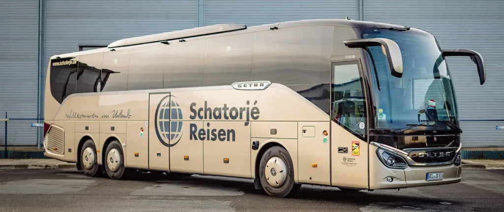 Moderner Reisebus von Schatorjé Reisen mit Firmenlogo und dem Schriftzug ‚Willkommen im Urlaub‘
